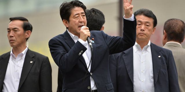 Japan's Prime Minister Shinzo Abe (C) delivers an election campaign speech in Tokyo's Ikebukuro, on July 4, 2013. Abe's ruling bloc is set to secure a majority in the upper house in this month's election, according to newspaper polls.