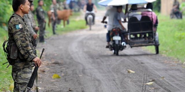 This file photo shows members of the southern Philippine rebel group, the Moro Islamic Liberation Front (MILF), lining a street as villagers pass by, in a town on Mindanao island, on September 19, 2009. The United States has warned Americans against travel to the southern Philippines just days after Australia and Canada issued similar advice.