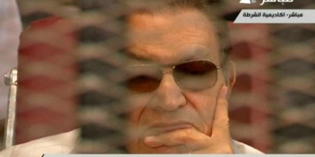 An image from Egyptian state TV shows ousted president Hosni Mubarak sitting behind bars during his retrial in Cairo on July 6, 2013.