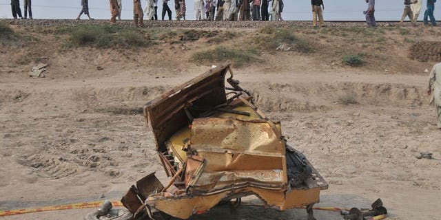 The mangled wreckage of a motorcycle rickshaw after a train collided with it in Khanpur town, Punjab province, on July 6, 2013. At least 14 people, including two children, were killed in the crash.