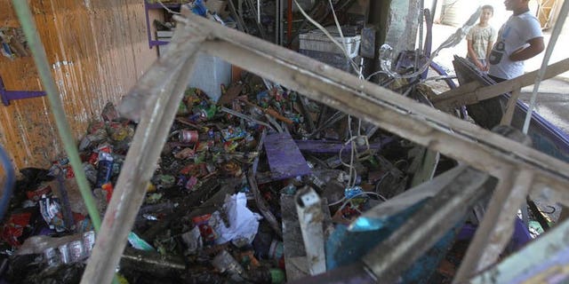 A man looks at a destroyed shop following a car bomb in the Shuala area of eastern Baghdad, on July 3, 2013. Bombings north of Baghdad on Saturday killed five people, including a police officer, police and doctors said, a day after attacks across the country left 23 dead.