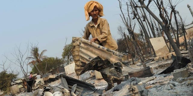 A man searches the remains of a burnt-out house in Meiktila on March 23, 2013. Myanmar has sentenced two Buddhist men to seven years in prison for murders during the religious violence.
