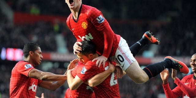 Manchester United's English forward Wayne Rooney celebrates after Dutch teammate Robin van Persie scored against Arsenal during an English Premier League game at Old Trafford in Manchester, northwest England, on November 3, 2012. English Premier League champions United on Monday announced that it had signed a five-year partnership with Russian airline Aeroflot.