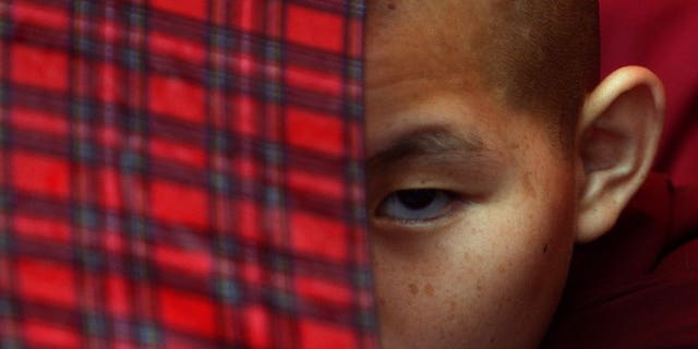 A young exiled Tibetan Buddhist monk watches festivities in Kathmandu on July 6, 2013. Chinese police opened fire on Tibetans marking the Dalai Lama's 78th birthday, shooting at least one monk in the head and seriously wounding several other people, two overseas groups said.