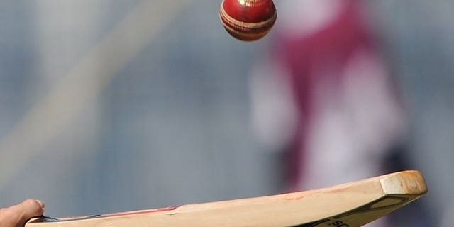 A cricketer tosses a ball with a bat in Mumbai on November 21, 2011. Sri Lanka cricket bosses banned two umpires named by an Indian television programme last year that claimed they were willing to make favourable decisions during matches for cash.