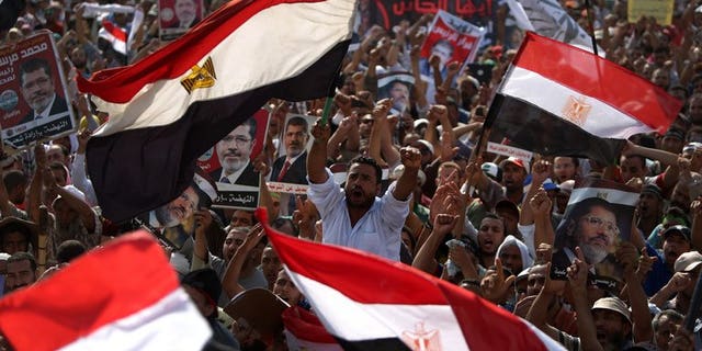 Egyptian supporters of deposed president Mohamed Morsi wave their national flag as they attend a rally in support of the former Islamist leader outside Cairo's Rabaa al-Adawiya mosque on July 8, 2013. The United Arab Emirates said it has offered Egypt an aid package of $3 billion, just days after it hailed the ouster of Islamist president Mohamed Morsi by the Egyptian army.