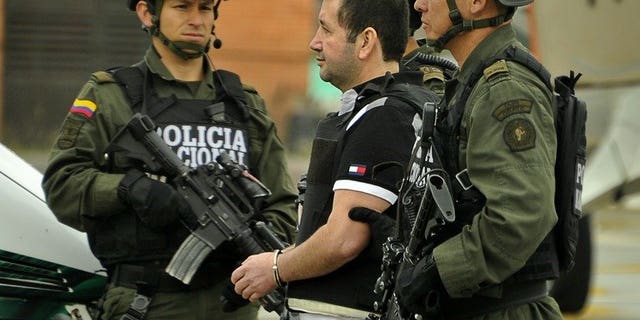 Colombian drug trafficker Daniel "El Loco" Barrera is escorted by police on July 9, 2013 in Bogota. The last of the major Colombian drug lords, Barrera, was extradited to the United States, where there had been a $5 million reward for his capture, Colombian police said.