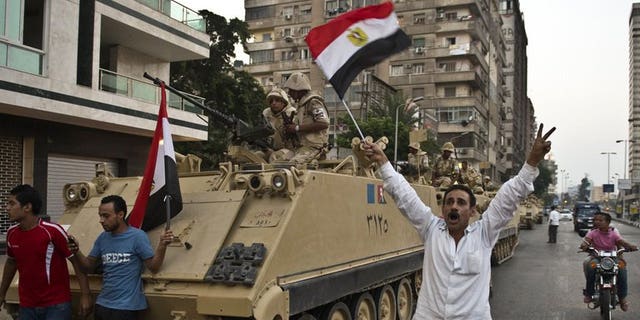 Demonstrators salute army tanks upon their deployment on a street leading to Cairo University on July 3. Amnesty International said on Wednesday it had evidence pointing to the "disproportionate" use of lethal force by Egyptian security forces, and called for them to be reined in to avoid "disaster".
