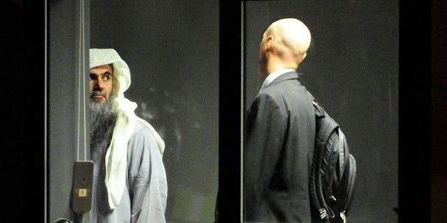 A photo release by the Home Office shows Abu Qatada waiting with an escort to board a jet at RAF Northolt, west London, on July 7, 2013. A military court has postponed until next week a bail application by the Islamist cleric, who faces terror charges in Jordan following his deportation from Britain.