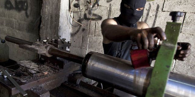 A man assembles an improvised cannon to be used by rebel fighters, at a factory in Syria's Aleppo city, on July 7, 2013. Islamic extremists fighting in Syria pose one of the most worrying threats to Britain and its allies, particularly if they gain access to the regime's stocks of chemical weapons, parliament's intelligence committee says.