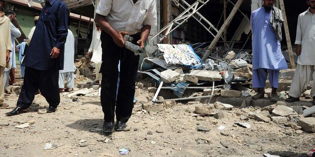 A Pakistani bomb disposal expert examines the site of an explosion in Karachi, on May 11, 2013. A bomb targeting one of Pakistani President Asif Ali Zardari's senior personal security officers has killed at least three people in Karachi.