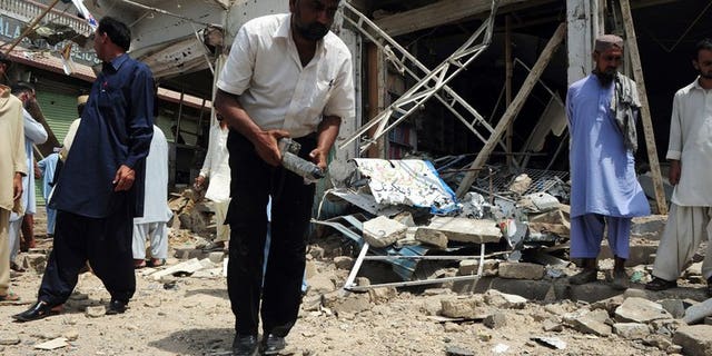 A Pakistani bomb disposal expert examines the site of an explosion in Karachi, on May 11, 2013. A bomb targeting one of Pakistani President Asif Ali Zardari's senior personal security officers has killed at least three people in Karachi.