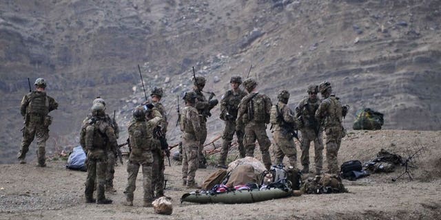 US soldiers gather near the scene of a helicopter crash in Afghanistan's Nangarhar province on April 9, 2013.