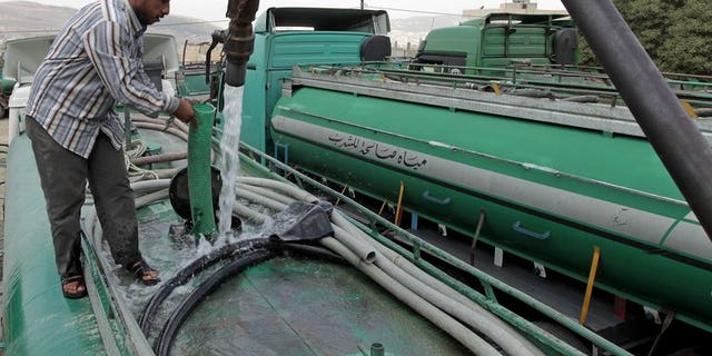 A Jordanian truck driver fills his tanker with water in Abu Nuseir, near the capital Amman on September 30, 2012. Jordan, one of the world's 10 driest countries, said it will start pumping water from a 300,000-year-old southern aquifer on Thursday to the capital and other cities to help them meet high demand.