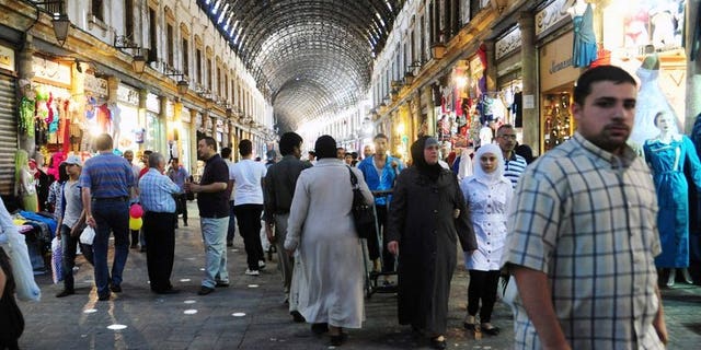 Syrians shop in the covered market in central Damascus on July 9, 2013 as they prepare for the Muslim holy fasting month of Ramadan. The new leader of Syria's opposition National Coalition called on Wednesday for international pressure on President Bashar al-Assad to accept a truce in the central city of Homs for the Muslim fasting month of Ramadan.