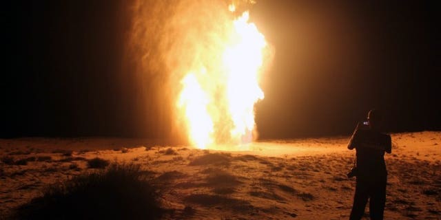 An Egyptian stands in front of a gas pipeline on July 22, 2012, which was blown up by attackers in Egypt's northern Sinai. Energy-poor Jordan said on Wednesday that gas supplies from Egypt will resume within 10 days following sabotage on Sunday to the export pipeline by militants in the Sinai Peninsula.