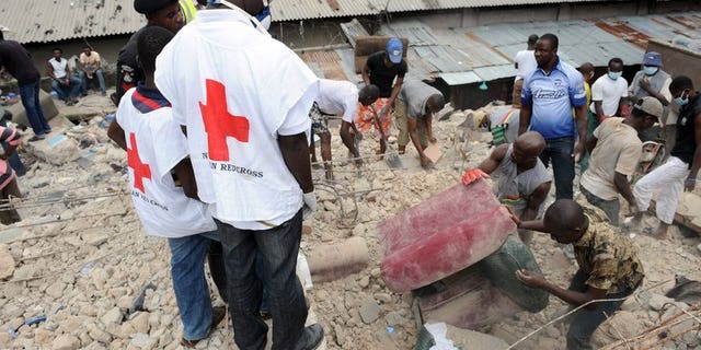 Red Cross officials help with rescue work after a building collapses at Idumota in Lagos in July 2011. A pregnant woman and a baby were among seven people killed after a residential building collapsed in Nigeria's most crowded city, Lagos, on Thursday.