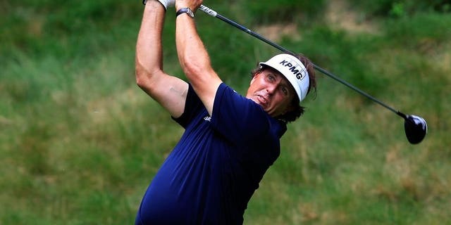 File image shows Phil Mickelson watching his tee shot on the seventh hole during round one of the Greenbrier Classic at the Old White TPC on July 4, 2013 in White Sulphur Springs, West Virginia. Mickelson made the most of near benign conditions to post a six-under-par 66 early on the opening day of the Scottish Open near Inverness.
