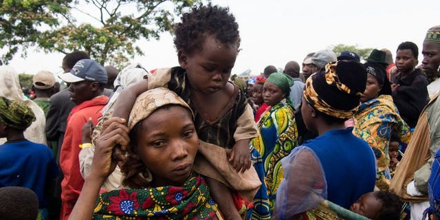 A mother carries her baby at Rwamwanja refugee camp, in the Kamwenge district, most of them from Democratic Republic of Congo, March 6, 2013.