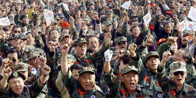 South Korean Vietnam War veterans shout slogans during a rally near the National Assembly in Seoul, October 29, 2004. South Korea's highest court on Friday upheld a ruling ordering two US Agent Orange makers to compensate 39 Vietnam War veterans, while sending another decision back to a lower court for review.