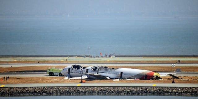 Investigators continue to inspect the scene of an Asiana Airlines Boeing 777 at San Francisco International Airport on July 7, 2013. South Korean aviation officials on Friday dismissed any suggestion that a deferential culture in which junior pilots were afraid to challenge their seniors played a part in the crash of an Asiana jet in San Francisco.
