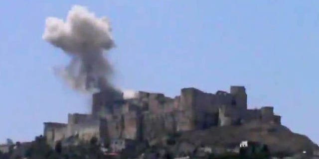 An image grab taken from a video uploaded on YouTube on July 12, 2013 shows smoke billowing from Syria's famed Krak des Chevaliers castle in central Homs province. AFP is using pictures from alternative sources. An air raid has damaged one of the fortress's towers, according to footage shot by activists.