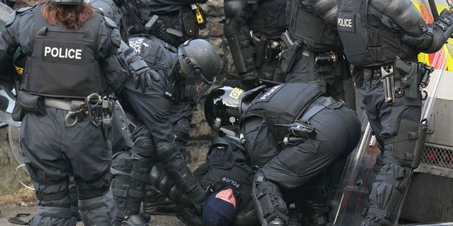 An injured policeman is carried away during clashes with Orangemen protesters in north Belfast, Northern Ireland, on July 12, 2013. Hundreds of extra police have been deployed to Northern Ireland following a night of rioting in Belfast that left 32 officers injured and a politician hospitalised.