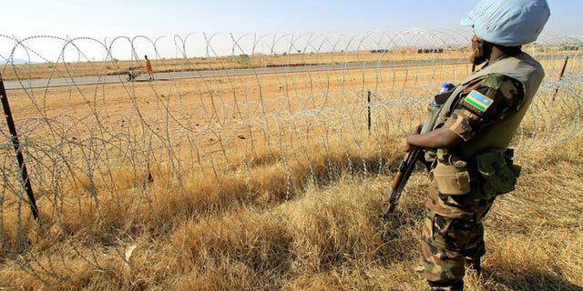 A peacekeeper serving with the joint United Nations-African Mission in Darfur (UNAMID) stands guard in a field in Zalingei in western Darfur on December 1, 2010. Seven peacekeepers have been killed in Sudan's Darfur region, the African Union-UN Mission said on Saturday, the worst-ever losses in the five-year history of the operation.