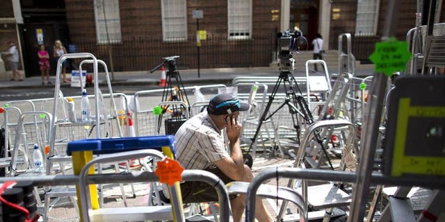 A journalist speaks on his mobile phone outside the Lindo Wing of St Mary's hospital in London, on July 13, 2013, where Prince William and his wife Catherine's baby will be born. The hospital is ready, the Wikipedia page and Twitter accounts are up and Britain's famously creative press are running out of ideas. But Sunday arrived with no sign of the royal baby.