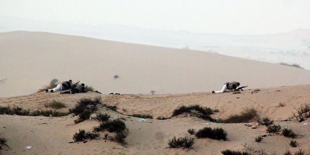 Egyptian security forces take position on a sand dune during an operation in the northern Sinai peninsula on August 8, 2012. Gunmen clashed with the Egyptian army on Sunday near the Israeli border, security sources said, in the latest violence to erupt in the Sinai peninsula since the ouster of president Mohamed Morsi.
