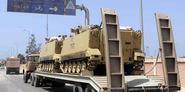 An Egyptian military truck carries armoured personnel carriers towards Al-Arish, in the northern Sinai on May 20, 2013. Militants killed at least three people Monday and wounded 17 when they fired on a bus carrying workers in Al-Arish, security and medical sources said.