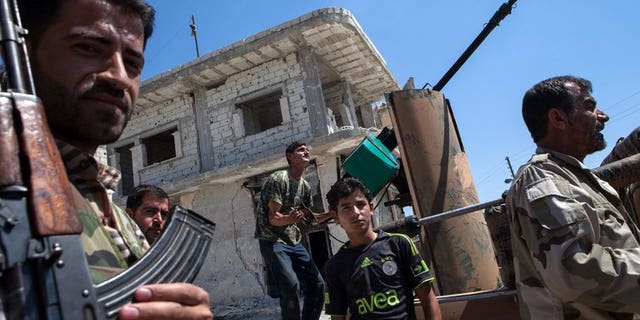 Syrian rebels try to locate a fighter plane in the village of Al-Rami in Idlib on June 22, 2013. Shelling and air raids by Syrian government forces against a string of villages in the northwestern province of Idlib killed at least 29 people, a watchdog said.