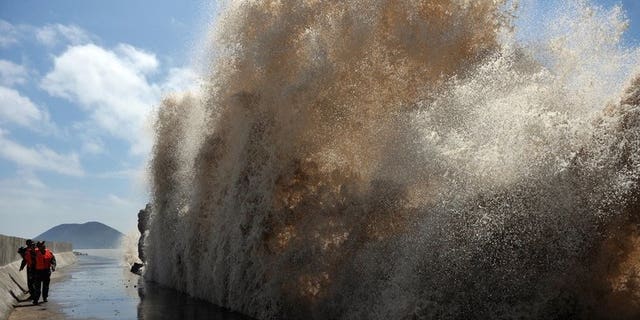 Huge waves surge up against the shoreline of Diaobin fishing port in Wenling, eastern China, on July 12, 2013. At least 295 people have been confirmed dead or missing after rainstorms and Typhoon Soulik hit China, causing floods, landslides and buildings to collapse.