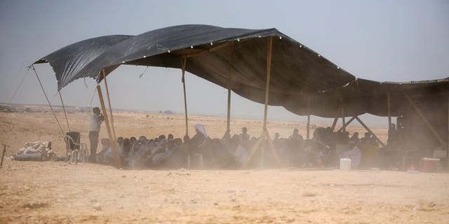 Bedouins attend Friday prayer under a tent in the Al-Araqib village located between Beersheba and Rahat in the Israeli Negev desert on May 14, 2010. Israeli police said they detained 15 Bedouin as hundreds of the tribesmen and women marched in the city of Beersheba to protest a government plan to resettle them.