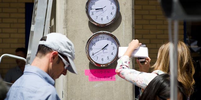 Clocks showing New York and "London Baby Time" are hung on a wall in the media pen outside the Lindo Wing of Saint Mary's Hospital in London, on July 15, 2013.