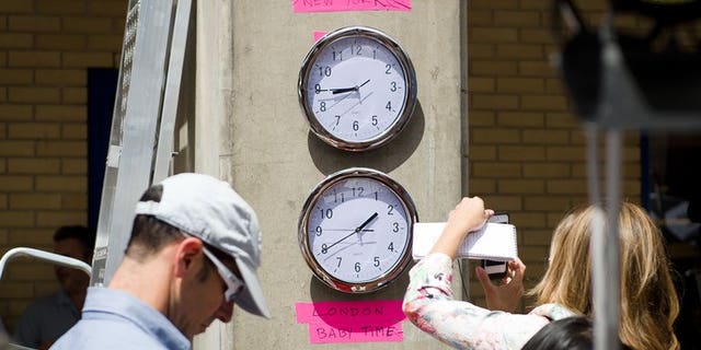 Clocks showing New York and "London Baby Time" are hung on a wall in the media pen outside the Lindo Wing of Saint Mary's Hospital in London, on July 15, 2013.