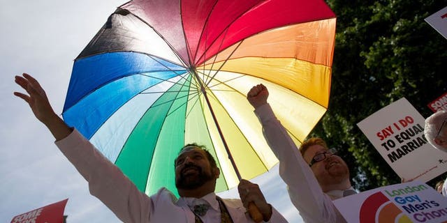 Gay campaigners rally outside the Houses of Parliament as the Marriage (Same Sex Couples) Bill gets an unopposed third reading by the Lords in central London on July 15, 2013. The first gay marriages in England and Wales are set to take place in 2014 after the legislation passed through parliament's upper chamber the House of Lords on Monday.