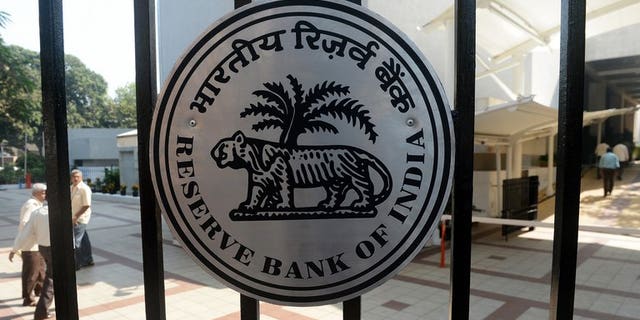 Indian employees walk into the Reserve Bank of India (RBI) headquarters in Mumbai on January 29, 2013. India's central bank hiked two interest rates late Monday to support the ailing rupee in a move that could slow the recovery of Asia's third-largest economy.