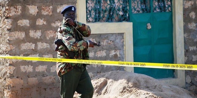 File picture shows a police officer guarding a house in Likoni, south of Kenya's main port of Mombasa, October 17, 2012. Gunmen in Kenya's port city Mombasa shot dead a Japanese man shortly after he withdrew money from a bank, police said Tuesday.