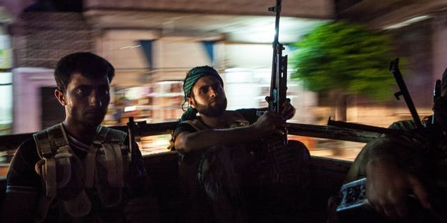 Syrian rebels head to the town of Bsankol in the northwestern province of Idlib on July 11, 2013. Britain is to give Syrian opposition fighters equipment to protect them against chemical weapons attacks "as a matter of special urgency", Foreign Secretary William Hague said.
