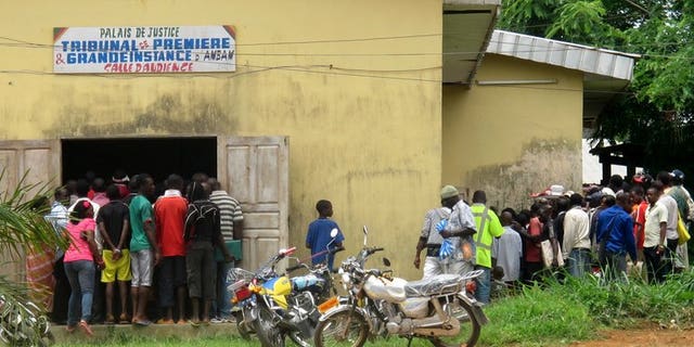 People stand in front of a tribunal in Ambam, Cameroon, during a homosexuality trial on March 15, 2012. A gay rights campaigner in Cameroon was found dead in his Yaounde home after being tortured, Human Rights Watch said on Tuesday.
