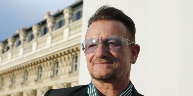 Bono, lead singer of Irish rock band, U2, poses after receiving the Commander of the Order of Arts and Letters (Commandeur de l'ordre des Arts et des lettres) insignia on July 16, 2013 in Paris.
