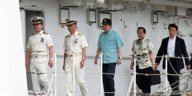 Japanese Prime Minister Shinzo Abe (C) inspects a Japan Coast Guard patrol boat off the remote Okinawan island of Ishigaki in the East China Sea, 2,000 kilometres (1,240 miles) southwest of Tokyo on July 17, 2013. Abe on Wednesday visited coastguards who patrol waters around islands at the centre of a dispute with China, as election campaigning stepped up a gear.