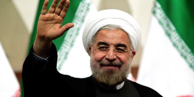 File picture taken on June 17, 2013 shows Iranian president-elect Hassan Rowhani waving as he attends a press conference in Tehran. Rowhani has brushed off threats of military action against the Islamic republic by Israeli Prime Minister Benjamin Netanyahu, saying such warnings only made him "laugh", media reported Wednesday.