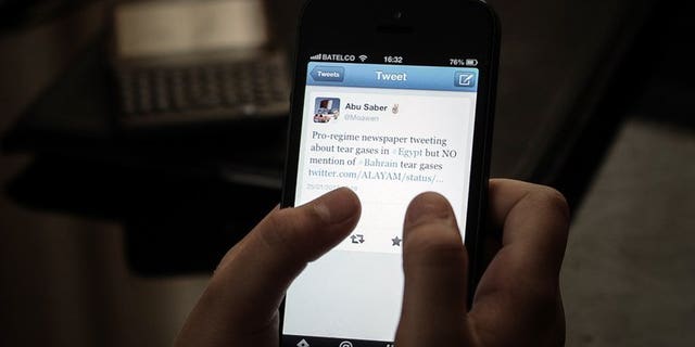 File picture shows a woman browsing Twitter on her smartphone in a coffee shop in the Bahraini capital Manama on January 29, 2013. Kuwait's appeals court on Wednesday upheld a 20-month jail term against a female opposition activist for making remarks on social network Twitter that were deemed insulting to the Gulf state's ruler.
