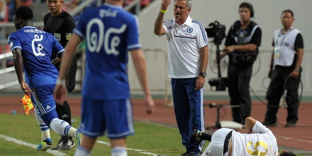 Chelsea football manager Jose Mourinho (C) gestures to his players as Cleiton Silva (R) of Singha All Star reacts during the exhibition match at Rajamangala National stadium in Bangkok on July 17, 2013. Chelsea beat Singha All Star 1-0.