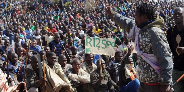 Miners sit together during a strike calling for increased wages, at a platinum mine in Marikana on August 16, 2012. Lawyers for relatives of 34 miners gunned down by South African police nearly a year ago said Wednesday they had pulled out of an already-troubled investigation into the deaths.