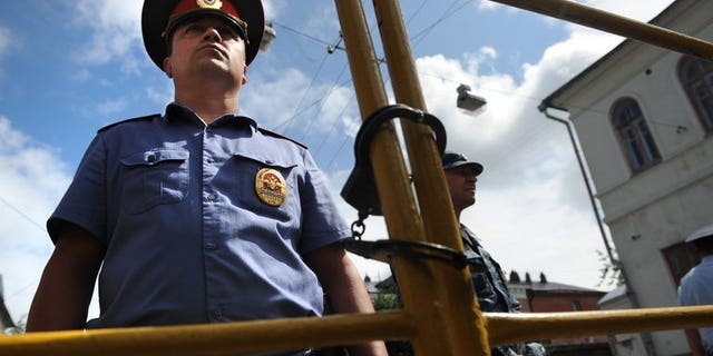 Police officers secure the courtyard of the tribunal in Kirov on July 18, 2013. British Foreign Secretary William Hague on Thursday warned against the "selective application of the rule of law" in Russia following the jailing of protest leader Alexei Navalny.