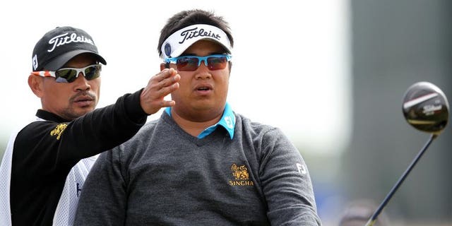 Thailand's Kiradech Aphibarnrat listens to his caddie before playing the 15th tee during the first round of the British Open at Muirfield golf course at Gullane in Scotland, on July 18, 2013. Kiradech battled to a one-over-par 72 after struggling with poor iron-play in the opening round of the British Open.