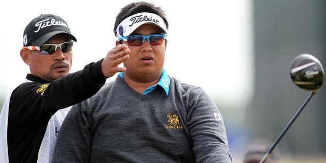 Thailand's Kiradech Aphibarnrat listens to his caddie before playing the 15th tee during the first round of the British Open at Muirfield golf course at Gullane in Scotland, on July 18, 2013. Kiradech battled to a one-over-par 72 after struggling with poor iron-play in the opening round of the British Open.